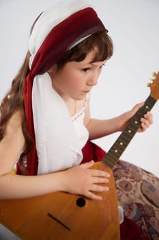 Portrait of Little girl in a stylized Tatar national costume on a white background in the studio. Photo shoot of funny young teenager who is not a professional model