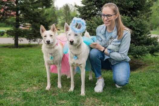 Happy woman walking with two white shepherd in park