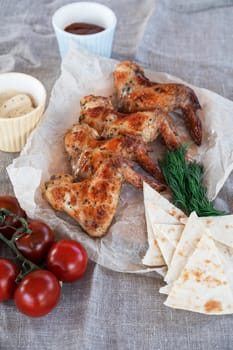 Ready spicy grilled chicken wings with greens and tomato. Summer rest concept