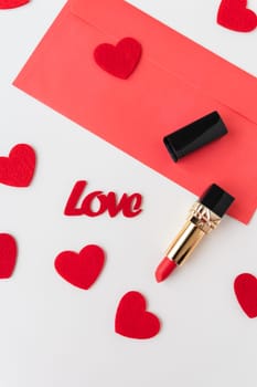 A red envelope with red lipstick on a background of small red hearts