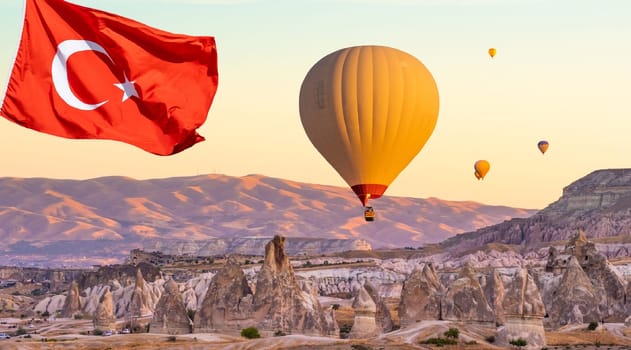 Turkey flag against hot air balloons flying on sunset sky in Cappadocia, Turkey