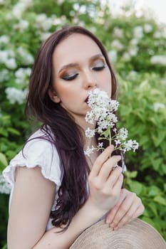 A fashionable girl with dark hair, a spring portrait in lilac tones in summer. Bright professional makeup