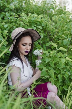 A fashionable girl with dark hair, a spring portrait in lilac tones in summer. Bright professional makeup