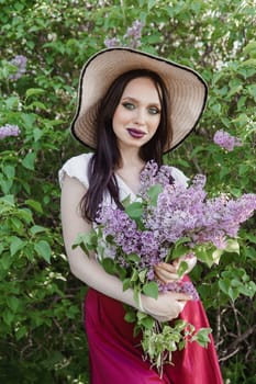 A fashionable girl with dark hair, a spring portrait in lilac tones in summer. Bright professional makeup