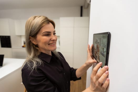 Woman at home using smart screen, automation domestic system.