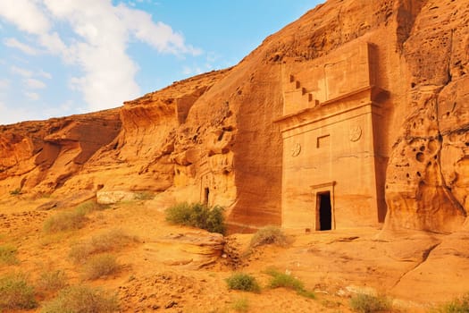 Old Nabatean architecture carved on orange sandstone wall at Jabal Al Ahmar, Hegra in Saudi Arabia, 18 ancient tombs are located here, 111 in whole Mada in Salih archaeological site.