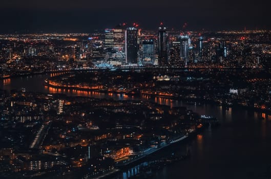 Aerial view of London at night, north eastern part, Isle of Dogs on river Thames, with Canary Wharf financial district.