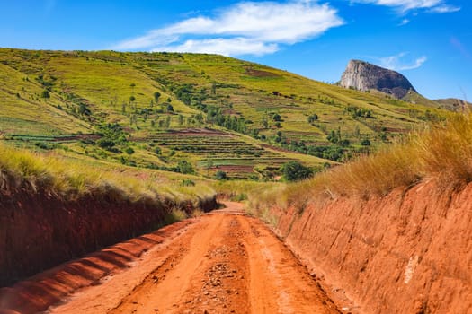 Red dust and mud road in poor condition with ridges formed after rain. Routes to Andringitra national park are bad during wet season in region near Ambalavao, Madagascar.