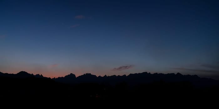 Silhouettes of low desert mountains with blue sky just after sunset - Venus and Jupiter visible - typical evening landscape near Yanbu, Saudi Arabia.