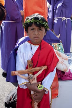 child in holy week procession with the cross of jesus christ in his hands. High quality photo