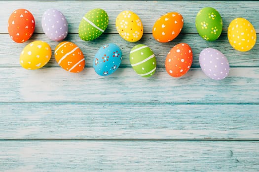 Easter Day Concept. Top view holiday banner background web design white colorful easter eggs painted on blue wood background with empty copy space, celebration greeting card, overhead, template