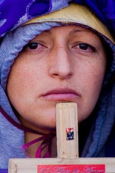 Nazarene woman with a cross of Jesus Christ in her hand and with a sad face. High quality photo