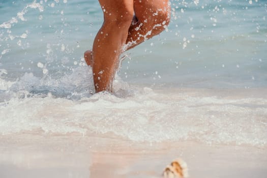 Sea beach travel - woman walking on sand beach leaving footprints in the white sand. Female legs walking along the seaside barefoot, close-up of the tanned legs of a girl coming out of the water