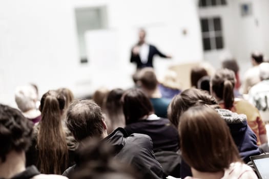 Speaker Giving a Talk at Business Meeting. Audience in the conference hall. Business and Entrepreneurship. Copy space on white board.