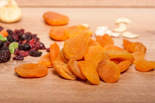 Dried fruits and nuts on wooden background in studio setup. Raw healthy lifestyle