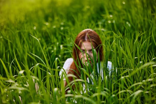 funny woman hiding in tall green grass. High quality photo