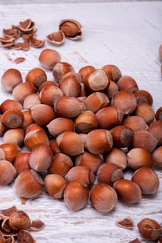 Brown Hazelnuts on white wooden background in studio photo. Healhty snacks