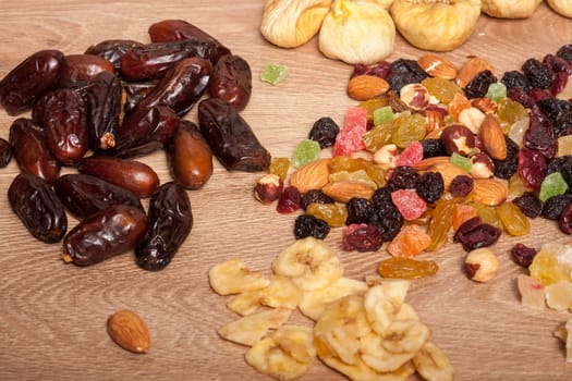 Mix of dried fruits on wooden background in studio photo. Healthy lifestyle