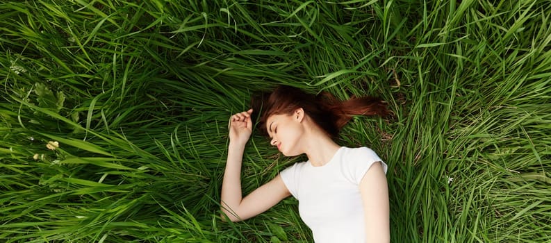 peaceful, happy woman lies in green tall grass. High quality photo