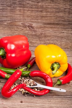 Sweet and hot pepper on wooden background. Healthy eating