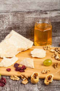 Fruits, grapes, cheese and honey on wooden background in studio photo. Healthy lifestyle