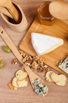 Cheese, nuts and honey on wooden background. Healthy food. Lifestyle