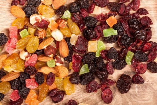 Dried fruits and nuts on wooden background in studio setup. Raw healthy lifestyle