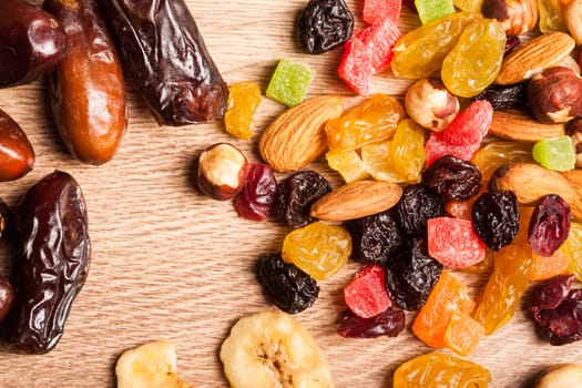 Dried fruits and nuts on wooden background in studio setup. Raw healthy lifestyle