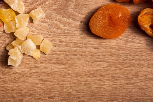 Dried fruits and nuts on wooden background in studio setup. Raw healthy lifestyle