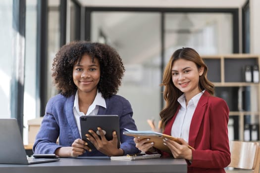 Two business people talk project strategy at office meeting room. Businessman discuss project planning with colleague at modern workplace while having conversation and advice on financial data report...