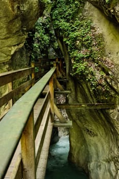 Vertical shot of a mossy wooden footbridge over the Seisenbergklamm gorge at Weissbach bei Lofer