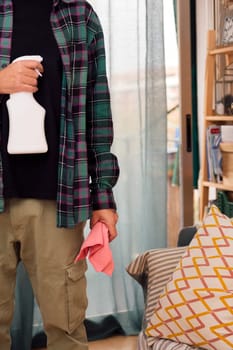 unrecognizable person holding cleaning spray and rag, home cleaning concept, copy space for text