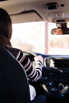 rear view of a young woman driving her camper van to new horizons, concept of road trip and nomad lifestyle, copy space for text