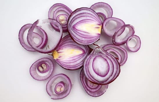 Red onions sliced ​​on a white cutting board. Top view.