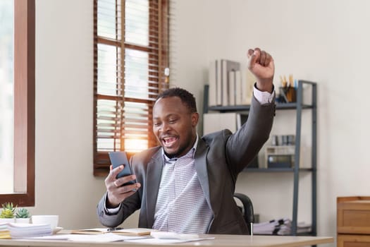 American African black man happy while reading email have a good news in smartphone. business finance and technology concept.