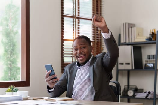 American African black man happy while reading email have a good news in smartphone. business finance and technology concept.