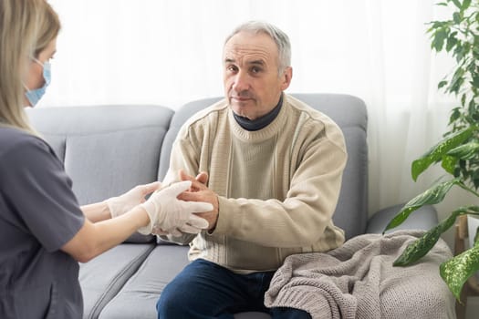 Kind female doctor embracing encouraging senior male patient in hospital. Happy healthy older man and his physician enjoying talking at nursing home. Elderly medical health care concept