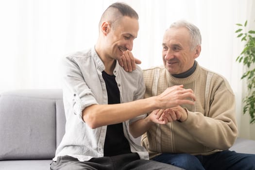 Help needed. Pleasant senior man sitting on the sofa.