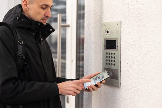 Hands man using security control application on smartphone when locking apartment door.
