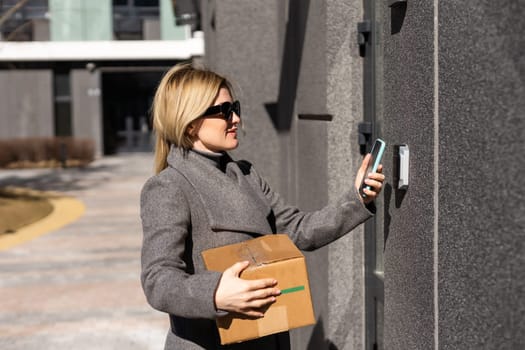Smart home concept - close up of woman use mobile phone to open electronic lock.