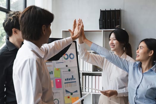 Group of business diversity workers standing with hands together high five at the office.