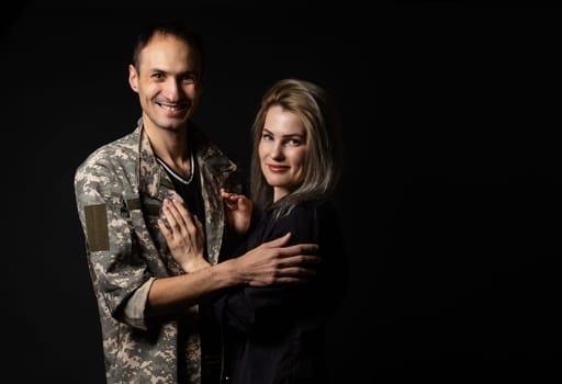 military man and his wife on a black background.