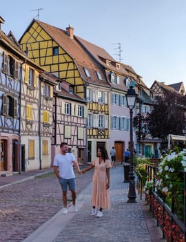 A couple of men and women on vacation at the romantic city Colmar, France, Alsace during summer, the Historic town of Colmar, Alsace region, France with beautiful canals called Le Petit Venice