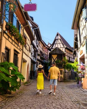 A couple of men and women on vacation in Eguisheim France Beautiful view of the colorful romantic city of Eguisheim near Colmar during summer