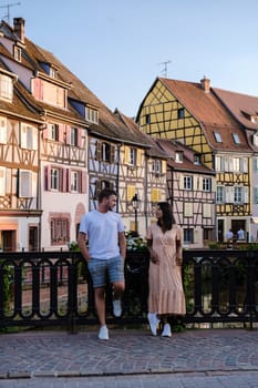 A couple of men and women on vacation at the romantic city Colmar, France, Alsace during summer, the Historic town of Colmar, Alsace region, France with beautiful canals called Le Petit Venice