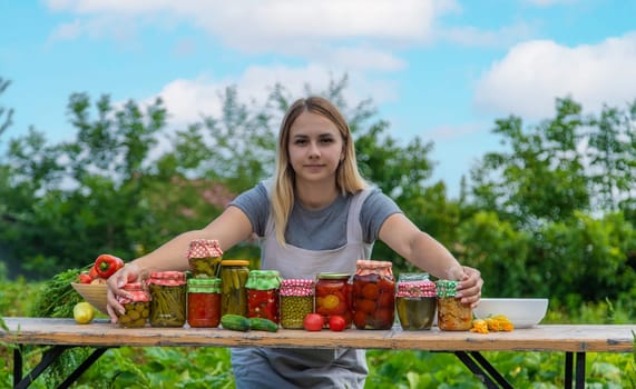 A woman preserves vegetables in jars. Selective focus. Food.