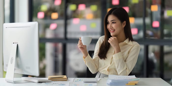 Beautiful Asian Banker or Accountant makes financial report and tax, analyzes profits. Accountant checks status of financial.