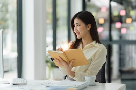 Beautiful Asian Banker or Accountant makes financial report and tax, analyzes profits. Accountant checks status of financial.