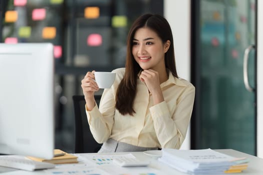 Beautiful Asian Banker or Accountant makes financial report and tax, analyzes profits. Accountant checks status of financial.