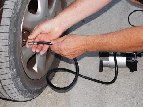 pumping up a car wheel with a pump close up